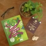کتاب مارک و دوپلو در کنار یک گلدان ، یک عینک و یک گذرنامه